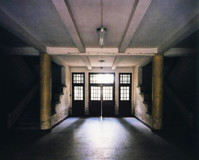 The entrance door of the building is softly illuminated, and the door closes gently to cut off the disturbance and gather an academic atmosphere